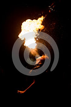 Man exhaling fire on a black background. Fire show