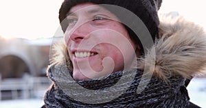 Man exhaling warm air from mouth and rubbing hands on a cold winter day