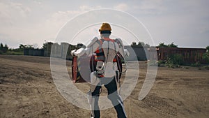 Man in exoskeleton carrying barrel on construction site