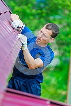 The man is an experienced worker repairing the roof of a residential private house