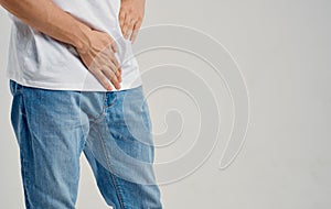 man experiencing pain below the belt in the groin and jeans t-shirt model