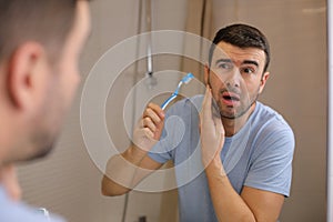 Man experimenting pain while brushing his teeth