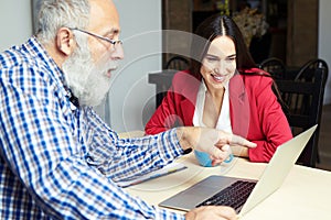 Man explaine something and woman looking at laptop