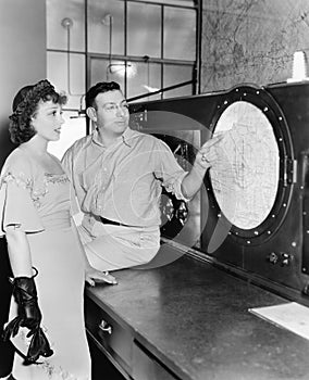 Man explaining about radar to a young woman in a control room