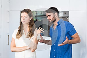 Man explaining to upset wife in kitchen