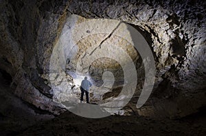 Man explorer in huge cave underground