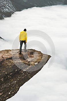 Man explorer standing on Trolltunga rocky cliff edge