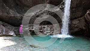 Uomo esamina alta montagna cascata canyon un grotta 