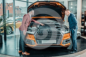 Man exploring the car under the capote. photo