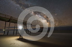 Man exploring a damaged pier at night