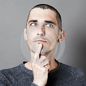 Man expressing doubt and reflection with finger on chin