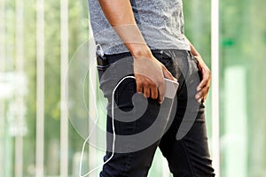 Man with external battery in pocket holding smart phone