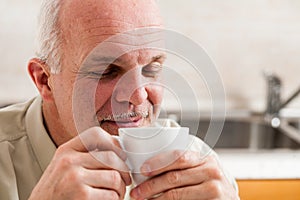 Man with eyes close holding coffee up to his nose