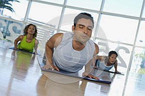 Man With Eyes Closed Exercising On Mat