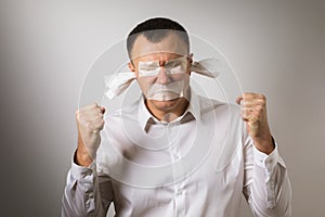 A man with eyes, mouth and ears sealed with painting tape. Concept stop being silent
