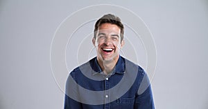 Man, face and laugh happy in studio grey background for comedy funny, joke meme or joy. Male person, model and portrait