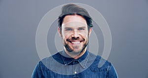 Man, face and laughing on grey studio background at joke, humor and funny story on mockup space. Portrait, person and