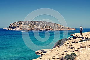 Man facing the Illa des Bosc island, in Ibiza, Spain photo