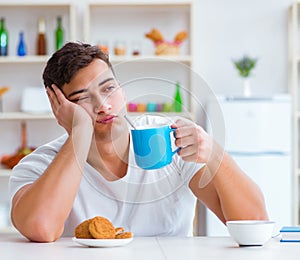 Man falling asleep during his breakfast after overtime work