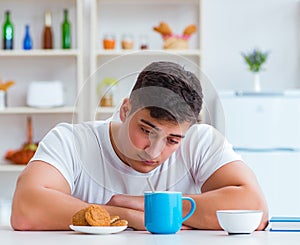 Man falling asleep during his breakfast after overtime work