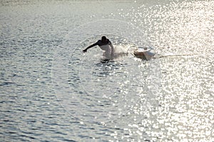 Man falling from supboard into the water.
