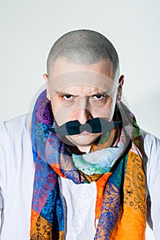 Man with false moustache and colored scarf