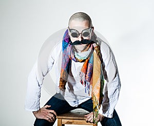 Man with false moustache and colored scarf