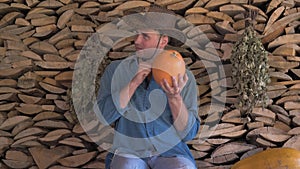 Man farmer checks the ripeness of the pumpkin and at the end thumb up