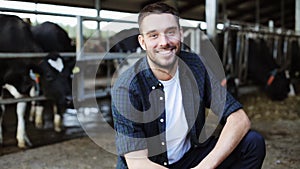 Man or farmer with cows in cowshed on dairy farm