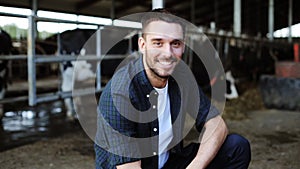 Man or farmer with cows in cowshed on dairy farm