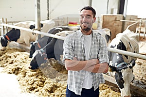 Man or farmer with cows in cowshed on dairy farm photo