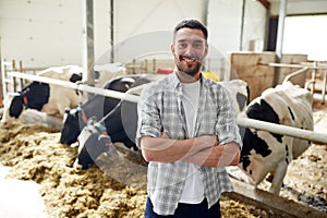 Man or farmer with cows in cowshed on dairy farm photo