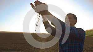 Man Farmer Examines Soil Quality on Fertile Agricultural Farm Land, Agronomist Checking Soil in Hands. farmer and soil