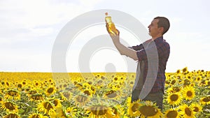 Man farmer hand hold bottle lifestyle of sunflower oil the field at sunset. Sunflower oil improves skin health and