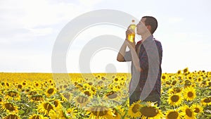 Man farmer hand hold bottle of sunflower oil lifestyle the field at sunset. Sunflower oil improves skin health and