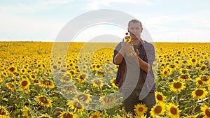 Man farmer hand hold bottle of sunflower oil n the field at sunset. Sunflower oil improves skin health and promote cell