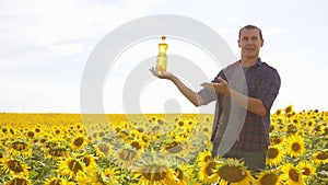 Man farmer hand lifestyle hold bottle of sunflower oil the field at sunset. Sunflower oil improves skin health and