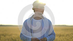 Man farmer in a hat walking in wheat field