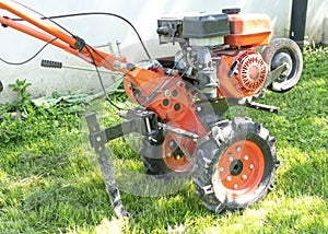 Man Farmer plows the land with a cultivator. Agricultural machinery: cultivator for tillage in the garden,motor cultivator photo