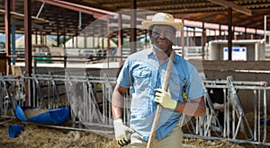 Man farmer posing at cowshed on farm