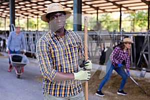 Man farmer posing at cowshed on farm