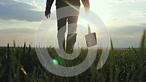 Man farmer a silhouette red neck holding shovel in his hand walking across green field a pile of dirt soil. Eco