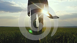 Man farmer a silhouette red neck holding shovel in his hand walking across green field a pile of dirt soil. worker