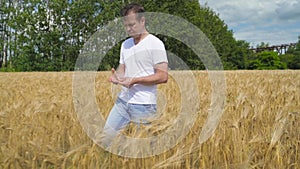 Man farmer walking down golden Barley field