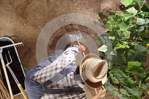 Hombre agricultor en negocios con una pala en verdura jardín romper arriba a 