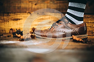 Man fashion brown shoe on wood background with striped socks