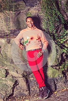 Young African American Man holding white flower, waiting for you