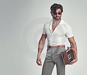 Man, fashion and retro with radio in studio, grey background and smart clothes with elegant style. Trendsetter, vintage