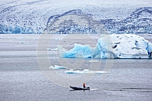 Man on a fast motor boat sailing on a glacier lagoon in Iceland