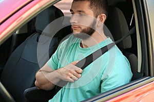 Man with fastened safety belt on driver`s seat in car